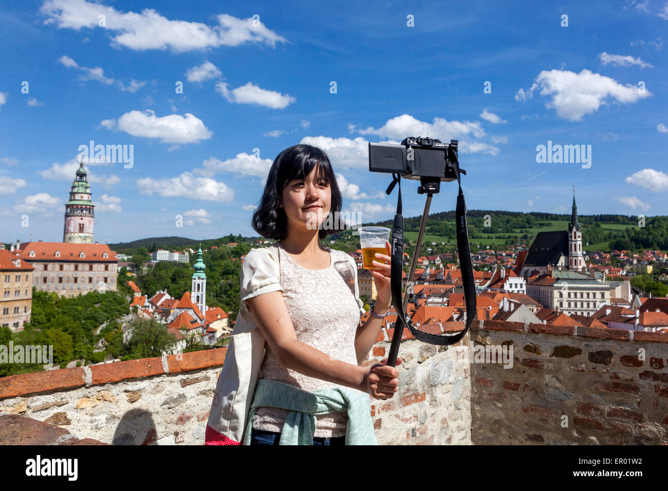 Junge Frau trinkt Bier, nimmt Selfie vor der Kamera mit Plastikbecher Cesky Krumlov Tschechische Republik Europa Stockfoto