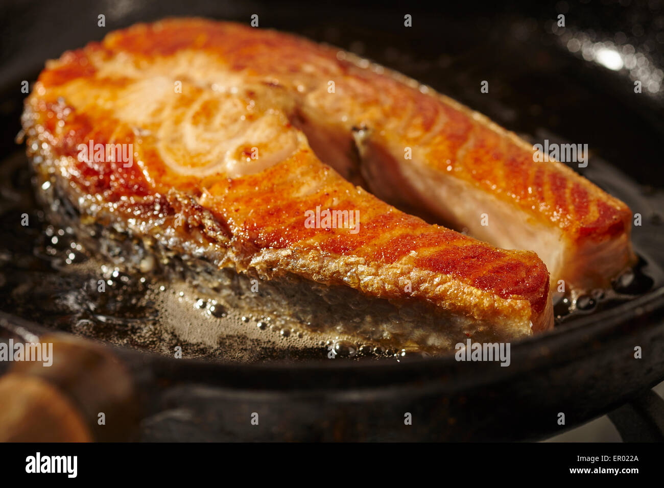 Lachssteak in einer gusseisernen Pfanne braten Stockfoto