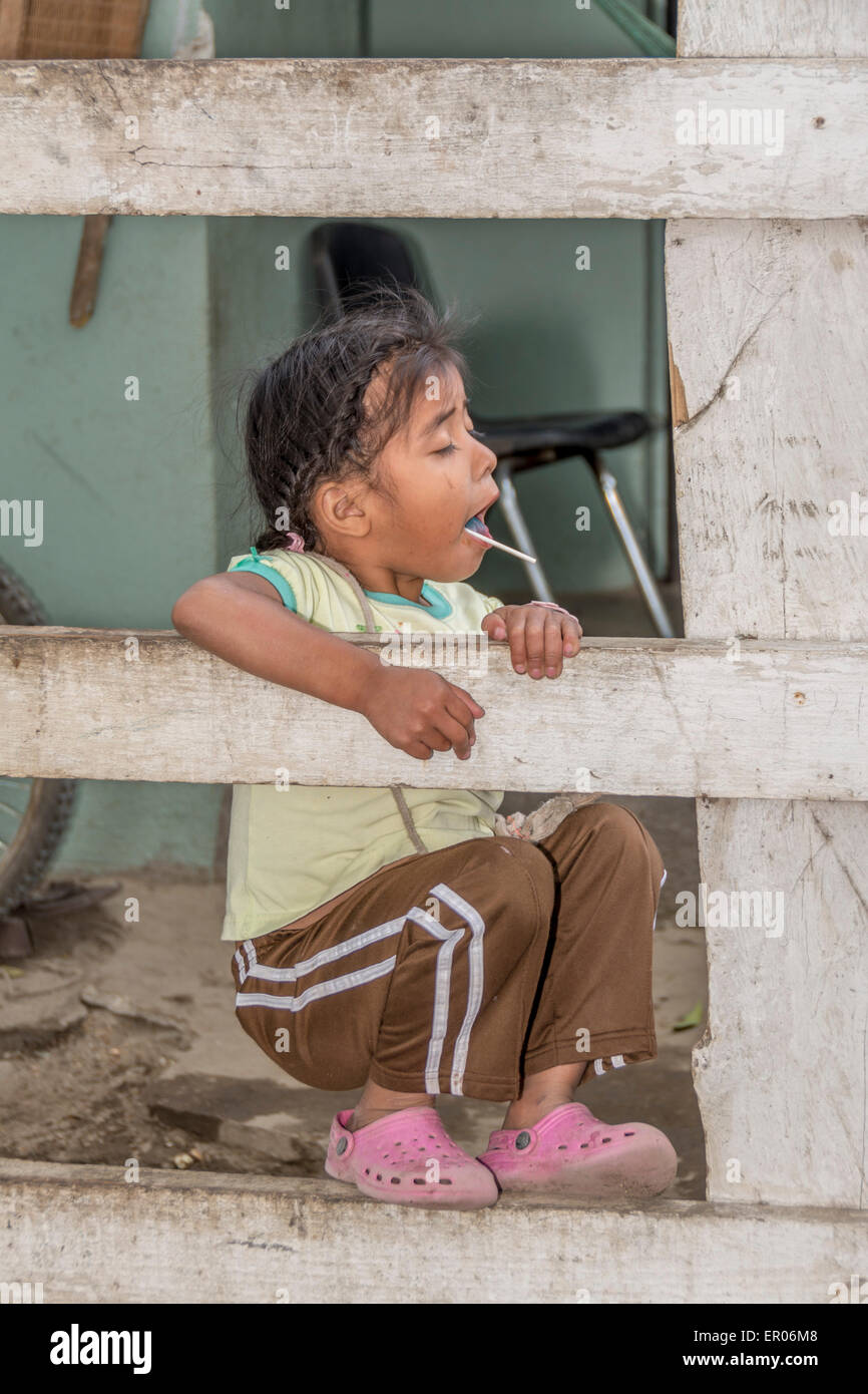 Junges Mädchen mit Süßigkeiten Saugnapf hängen an einem Zaun in Guatemala Stockfoto