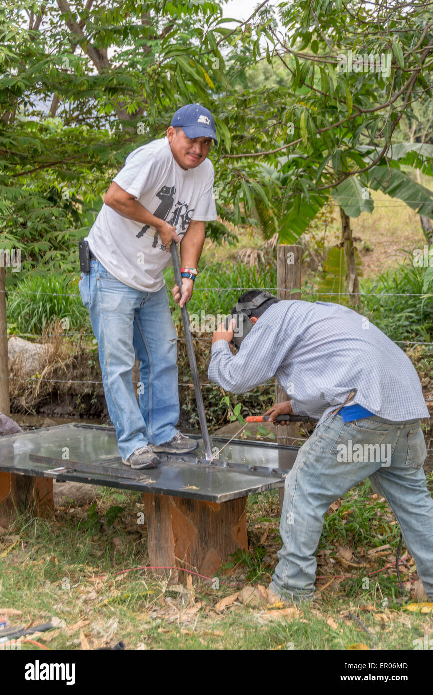 Männer, die Reparatur ein Metalltor mit einem elektrischen Schweißer in Guatemala Stockfoto
