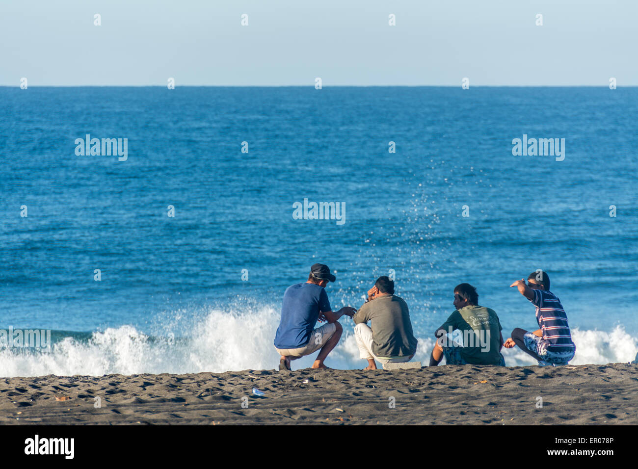 Guatemaltekische Männer sitzen am Strand von El-Hawaii-Guatemala Stockfoto