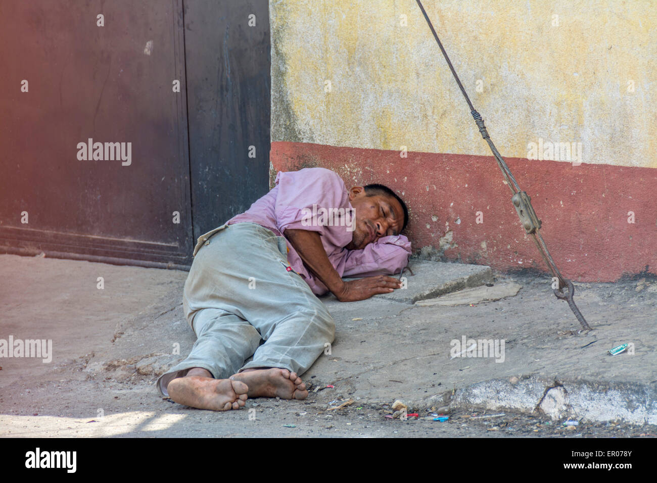 Alkoholische Mann schlafend auf dem Bürgersteig in Guazacapan Guatemala Stockfoto