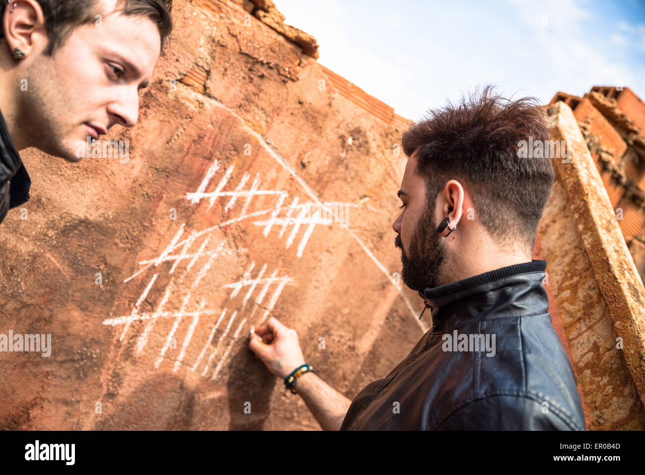 Zwei Jungs Couning Tage mit Kreide Markierungen an der Wand Stockfoto