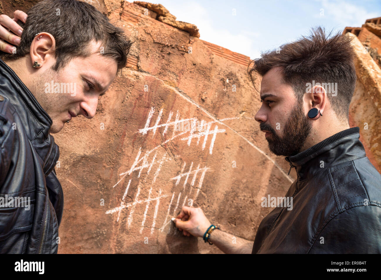 Zwei Jungs Couning Tage mit Kreide Markierungen an der Wand Stockfoto