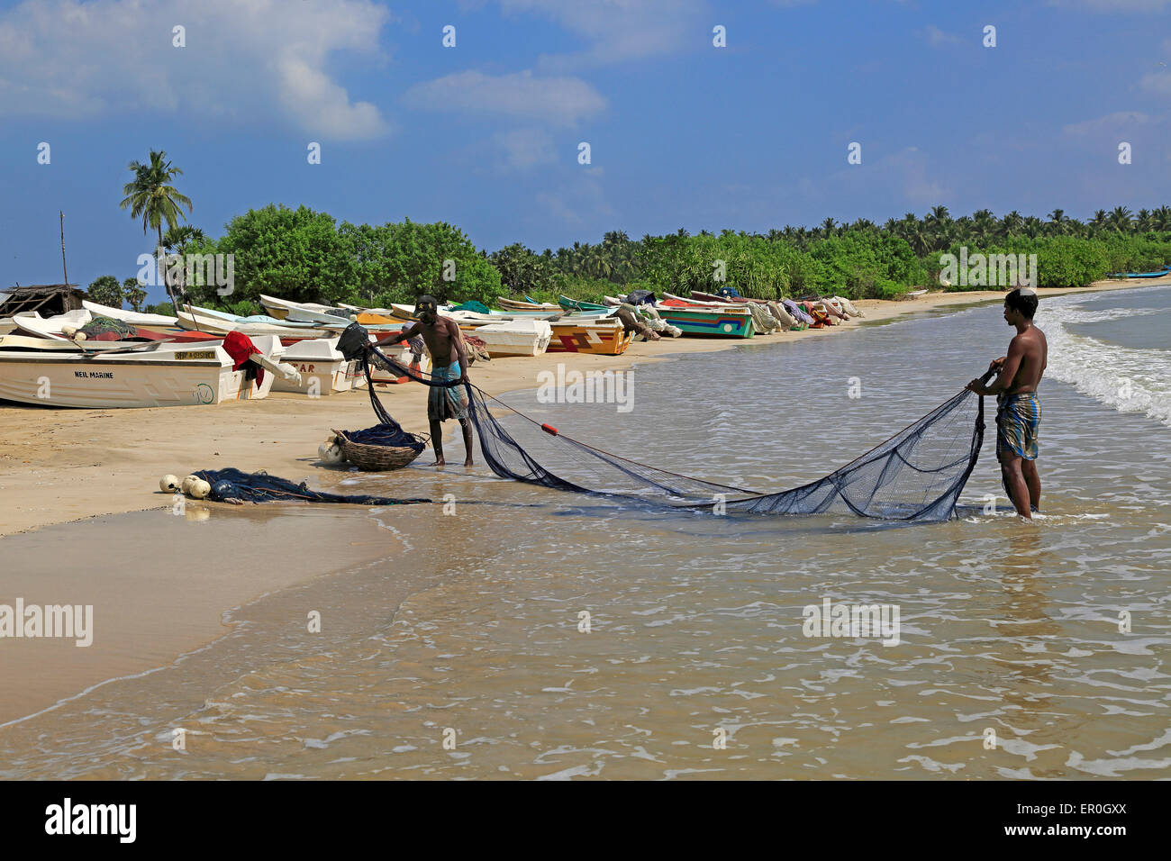 Männer mit Fischernetzen am tropischen Strand von Pasikudah Bay, Eastern Province, Sri Lanka, Asien Stockfoto