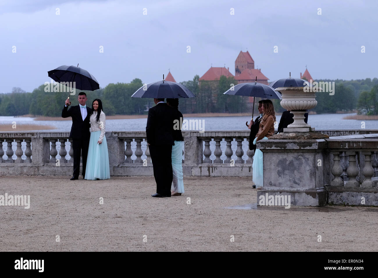 Paare in eleganter Kleidung, die während einer Fotosession vor der Hochzeit im Garten des Uzutrakis Manor Palace posieren, einem Wohnsitz aus dem späten 19. Jahrhundert der Familie Tyszkiewicz in Uzutrakis, am Ufer des Galve-Sees, gegenüber dem berühmten Schloss Trakai. Litauen Stockfoto