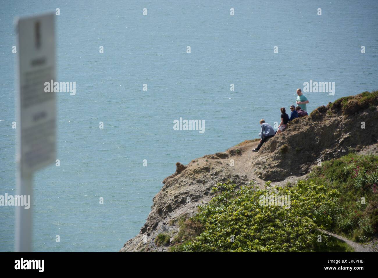 Menschen genießen die Sonne und die Aussicht saß auf der Klippe mit Blick auf Aberystwyth. Stockfoto