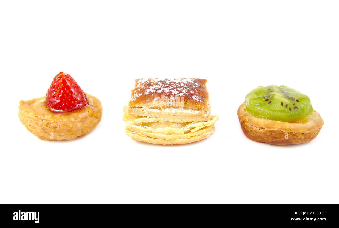 Drei spanische "Pastelitos": kleine Kiwi, Erdbeere und Hojaldre Torten auf weißem Hintergrund Stockfoto