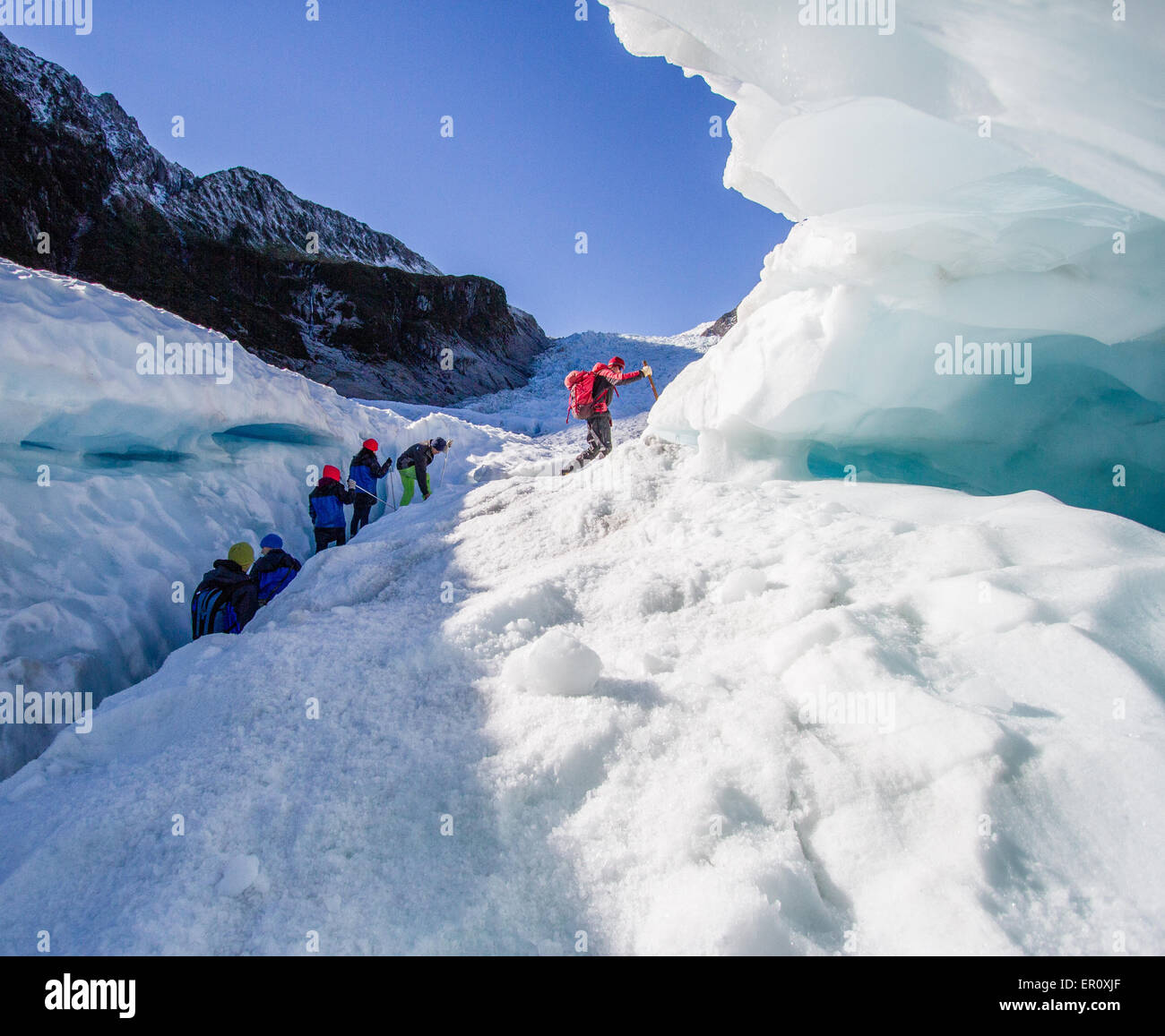 Klettern, Partei und ihre Führer eine Eis-Gletscherspalte zu verhandeln und Überhang am Fox-Gletscher auf der Südalpen Neuseelands Stockfoto