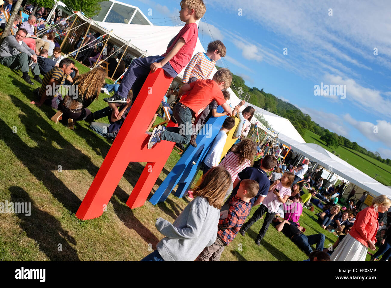 Hay Festival Powys, Wales, UK Mai 2015 Hay Festival Kinder auf dem Heu Festival heute eine Chance zu spielen auf dem riesigen Heu-Schild in der späten Nachmittagssonne genießen. Das Festival hat viele Veranstaltungen mit Autoren und Schriftsteller. Stockfoto