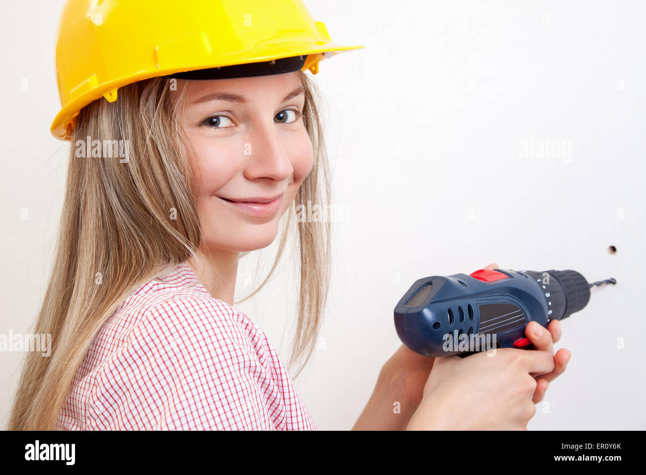 Junge Frau die DIY Arbeit und Schutzhelm tragen Stockfoto