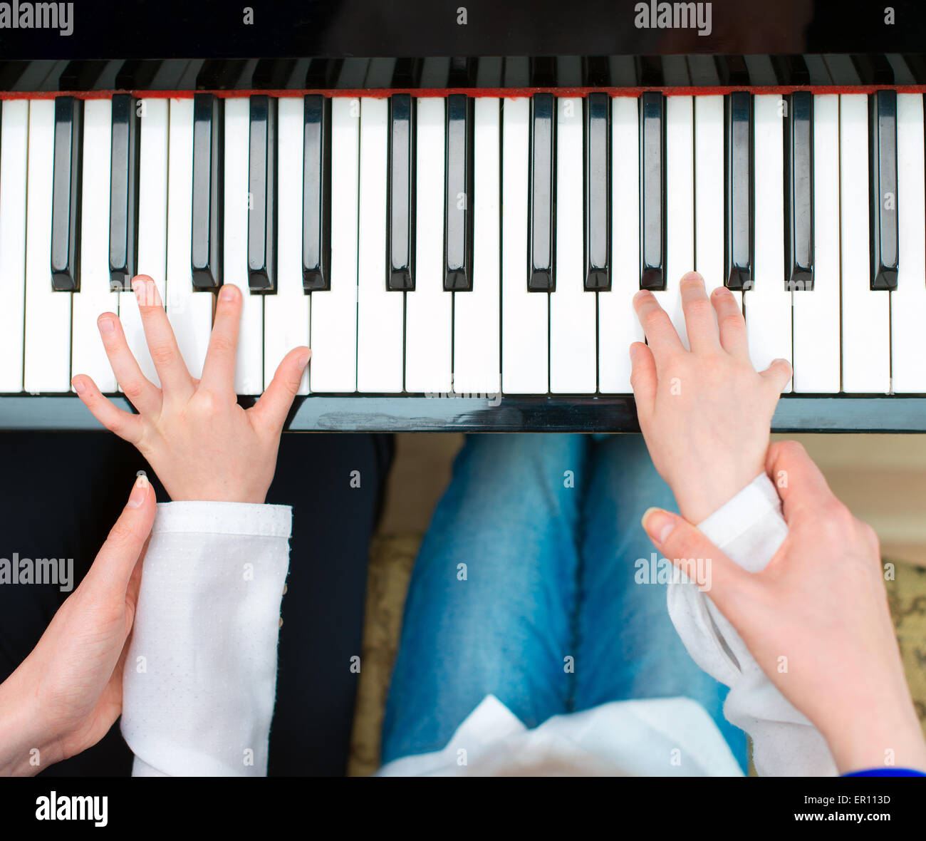 Frau unterrichtet kleine Mädchen auf das Klavier zu spielen. Stockfoto