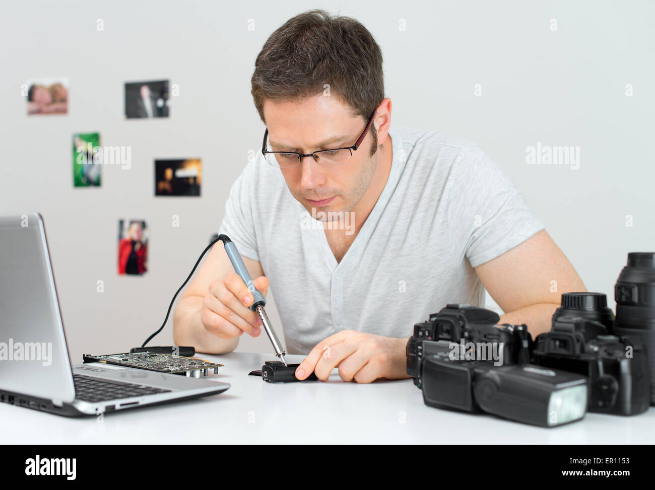 Fotograf Löten wireless flash Trigger an seinem Arbeitsplatz. Stockfoto