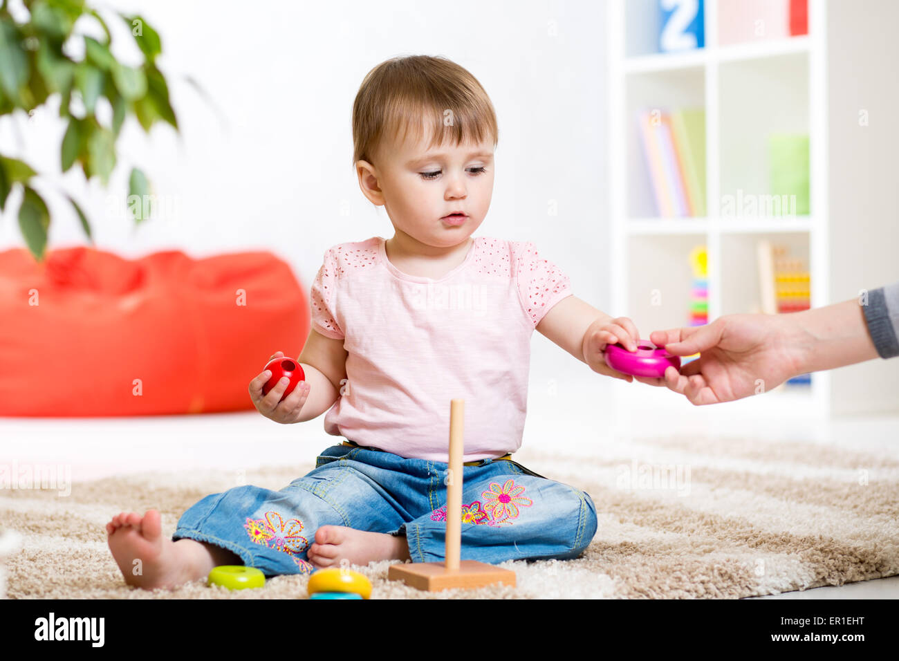 Kind Mädchen spielt mit Spielzeug drinnen zu Hause Stockfoto