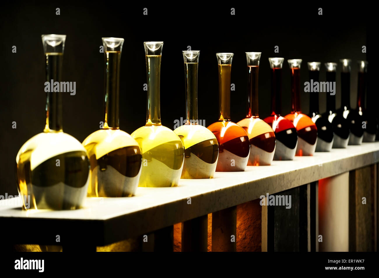 Verschiedene Arten von Wein in großen Spezialflaschen auf schwarzem Hintergrund Stockfoto