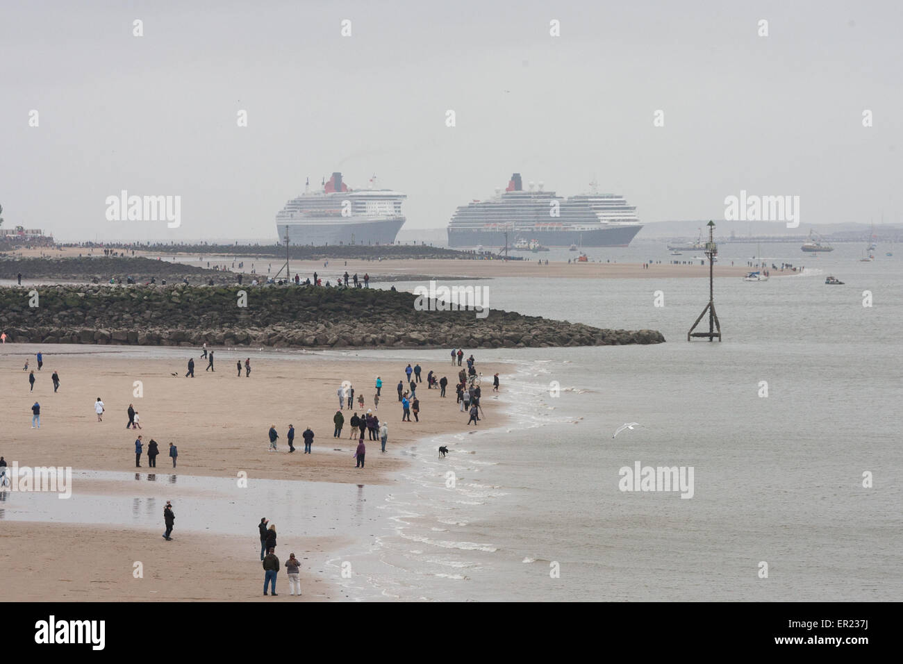 Liverpool, Vereinigtes Königreich. 25. Mai 2015. Menschen versammeln sich am Strand von Seacombe wie der Queen Elizabeth und Queen Victoria Segeln auf den Mersey zu ihrer Schwester Schiff Queen Mary 2. Bildnachweis: Adam Vaughan/Alamy Live-Nachrichten Stockfoto