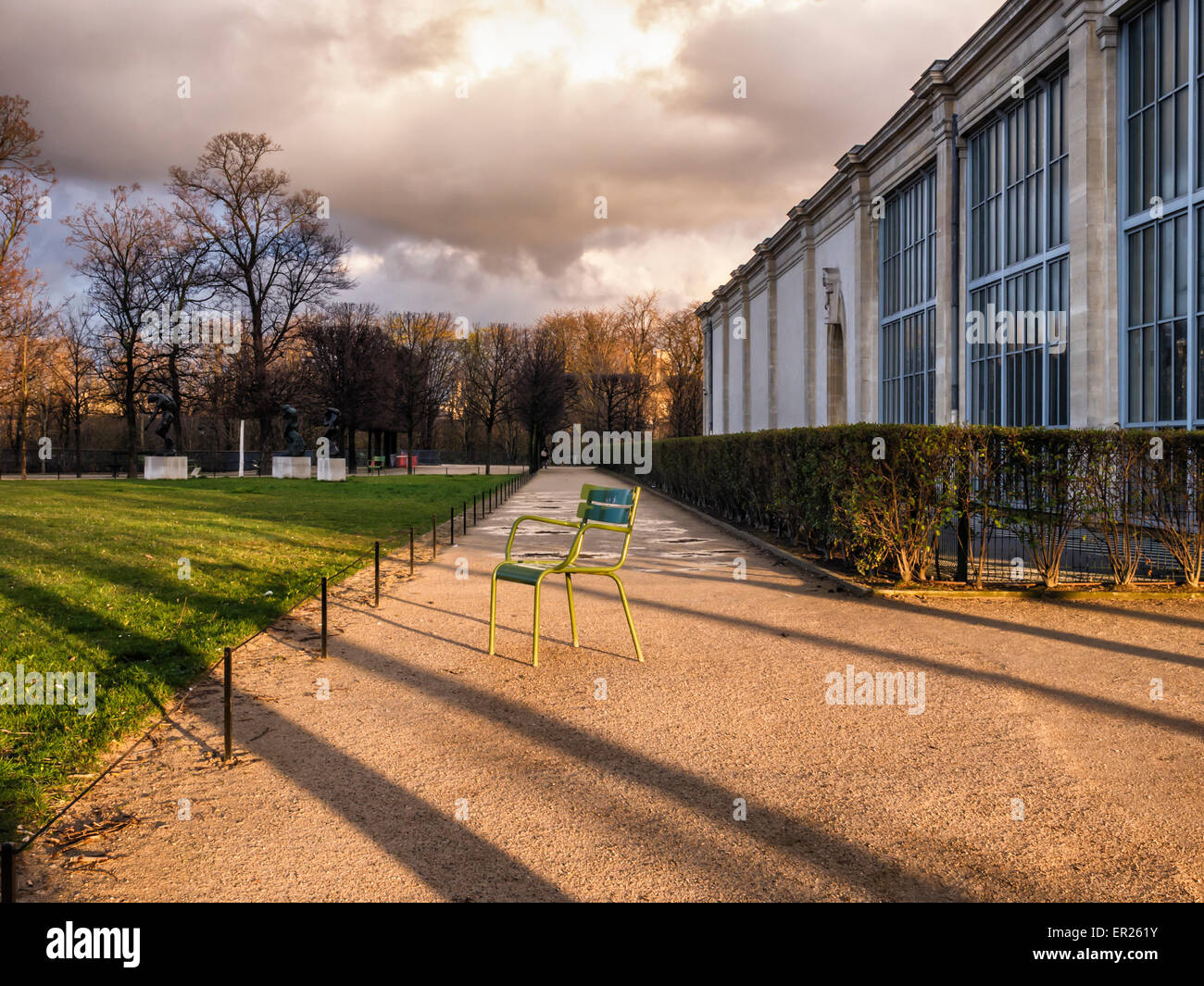 Musee de l ' Orangerie Kunstgalerie, Paris Jardin des Tuileries - Außenansicht mit einsamen Stuhl, Sonnenlicht und Wolken Stockfoto