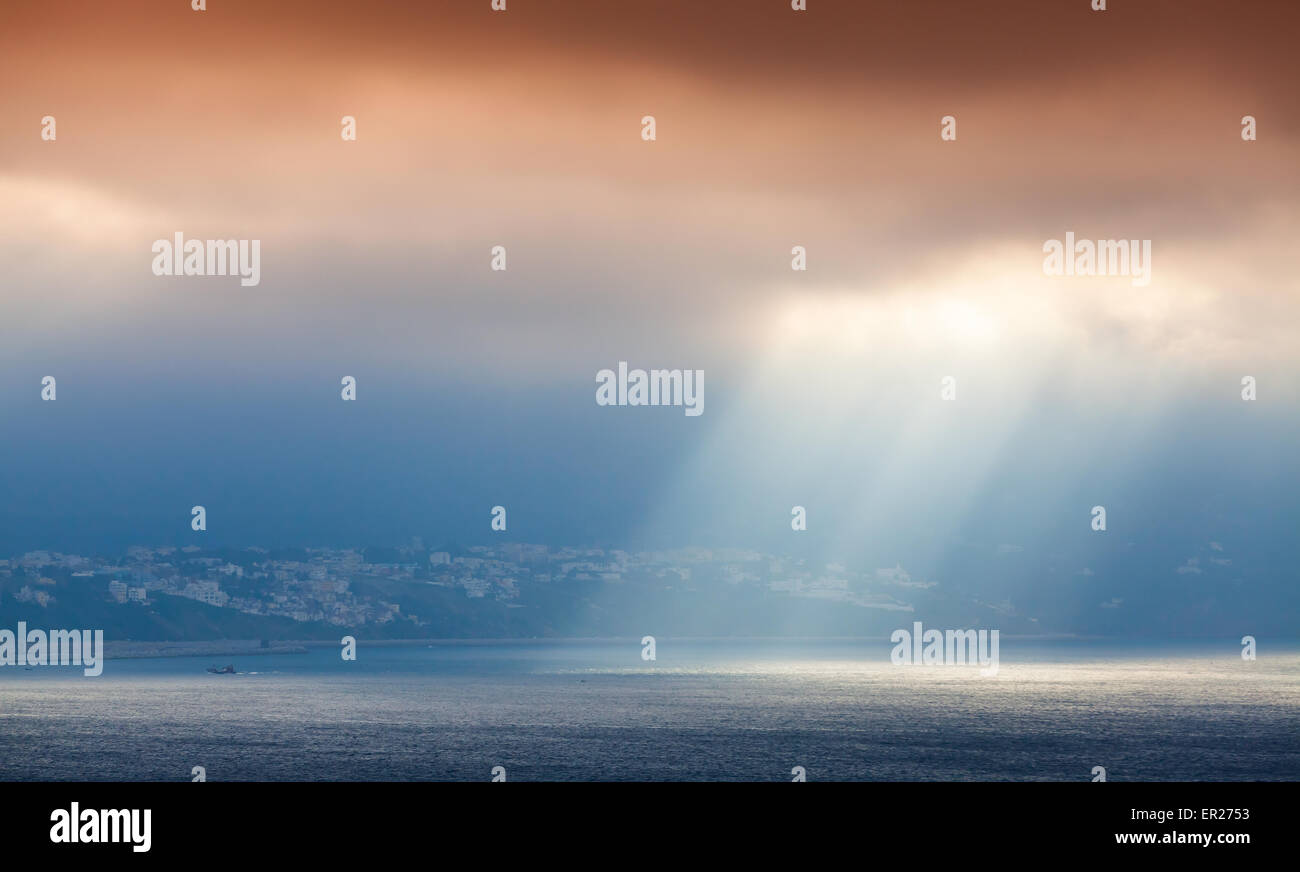 Volume Sonnenlicht geht durch dunkle orange Wolken. Bucht von Tanger, Marokko, Afrika Stockfoto