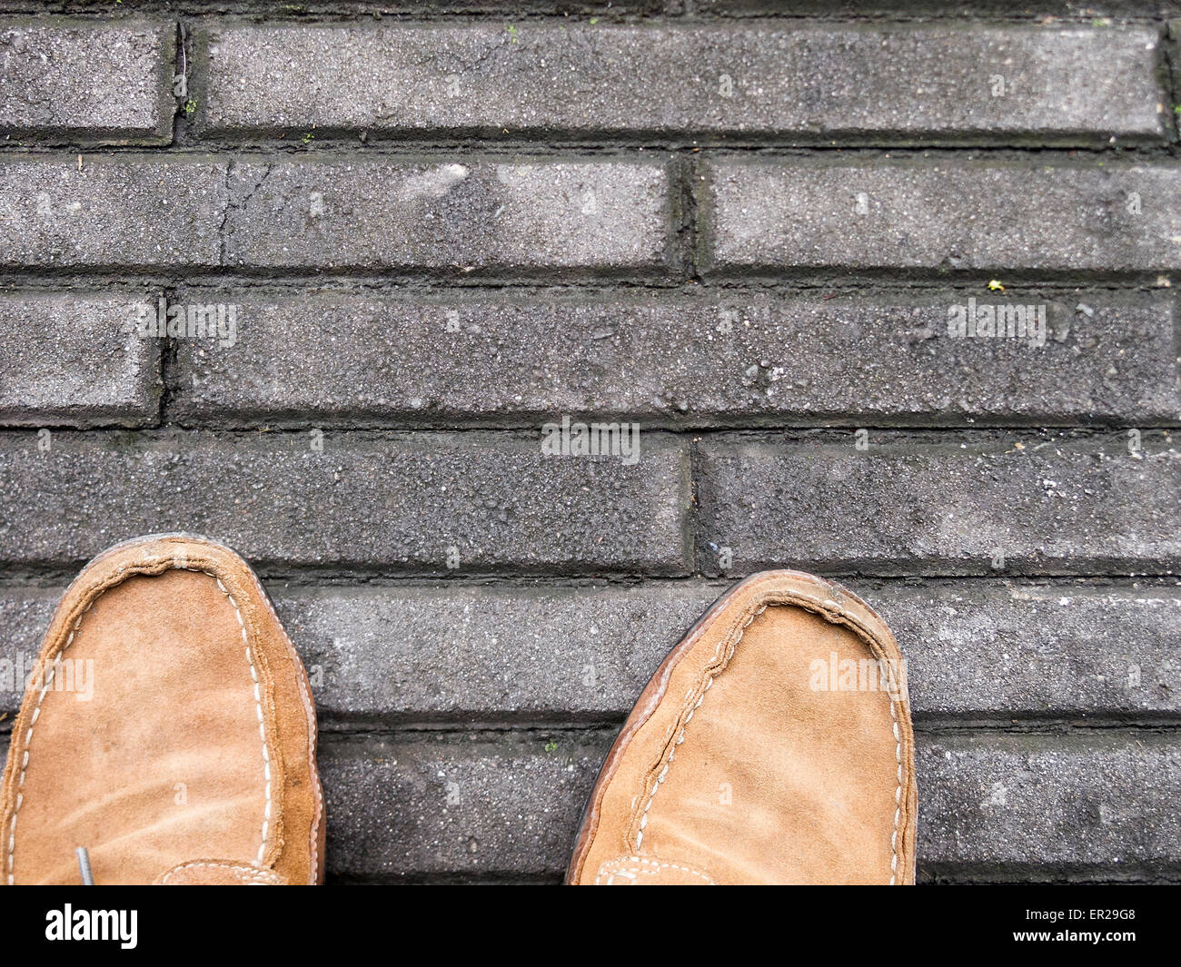 Männlich, braune Wildlederschuhe auf Betonplatten Stockfoto