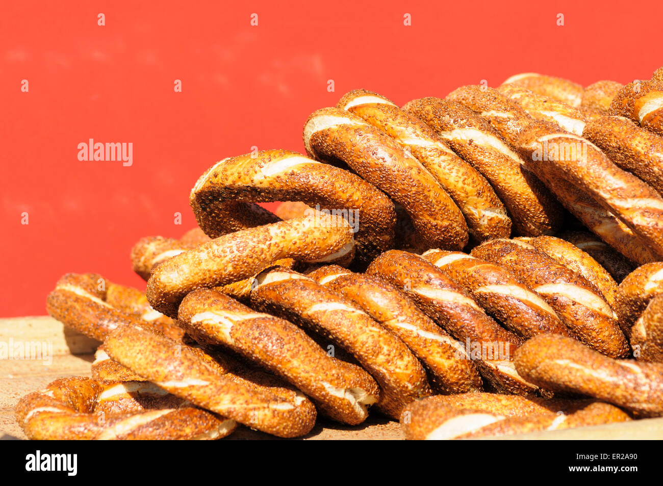 Gestapelte Sesam Samen beschichtete Simit, Turksih Runde Brot vor einem roten Hintergrund, Istanbul, Türkei Stockfoto