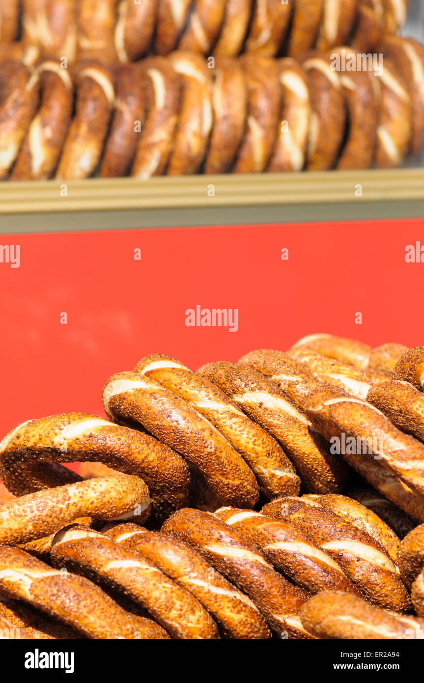 Gestapelte Sesam Samen beschichtete Simit, Turksih Runde Brot vor einem roten Hintergrund, Istanbul, Türkei Stockfoto