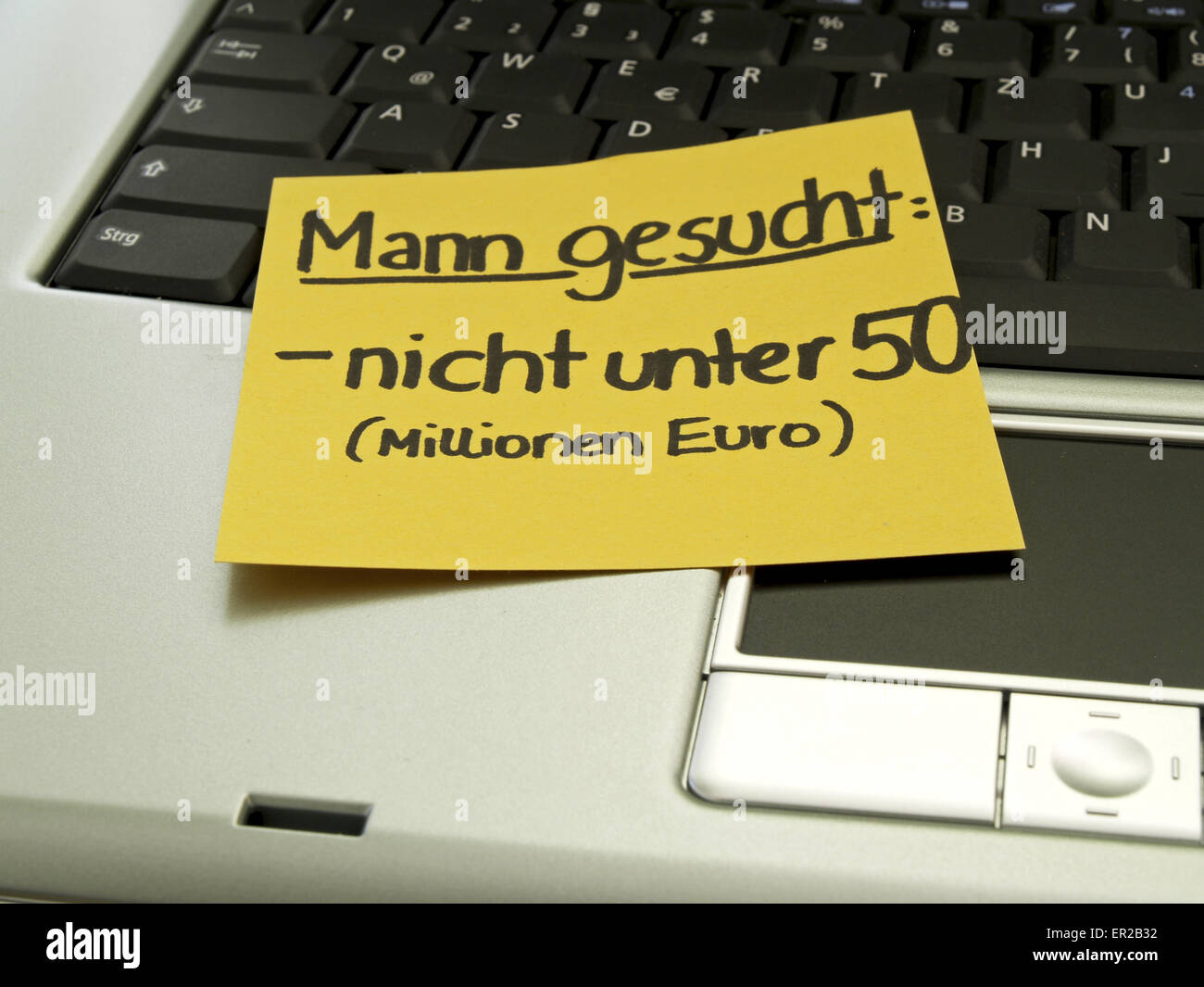 Memo-Hinweis auf Notebook, Suche einen Mann, nicht unter fünfzig (Mio. Euro) Stockfoto