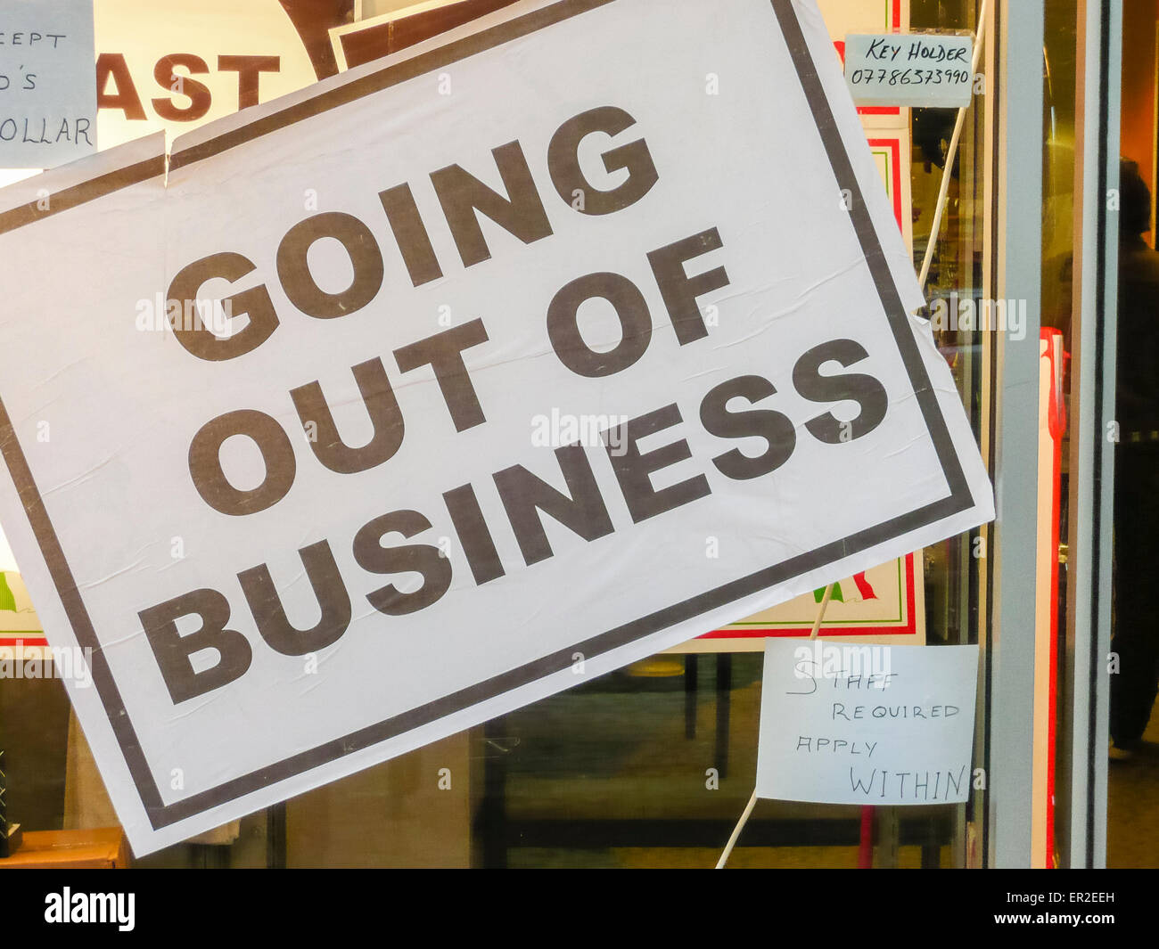 Melden Sie sich im Fenster eines Shops sagen "Going Out of Business", aber auch Werbung für das Personal. Stockfoto