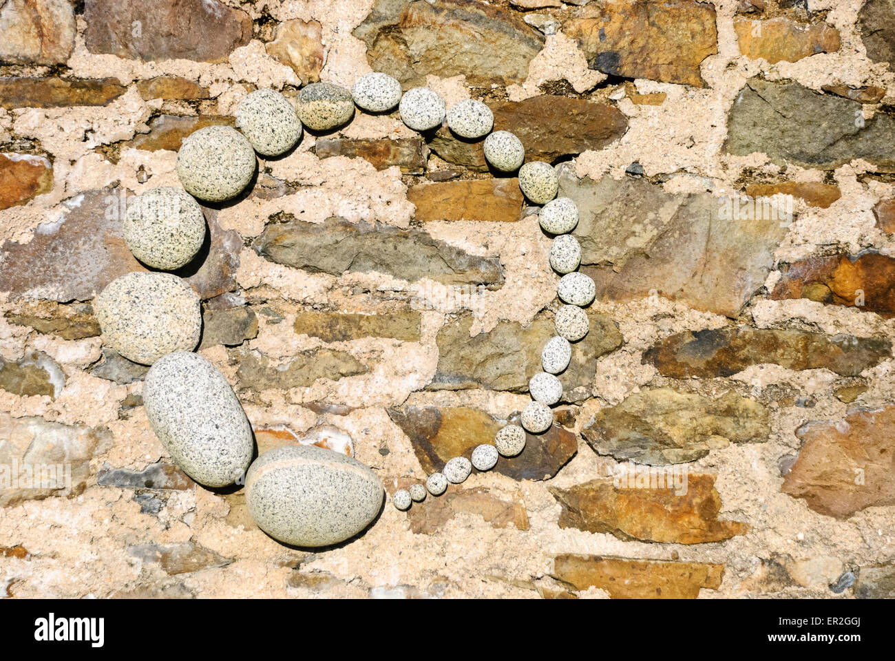 Steinen auf einer Wand in einem künstlerischen Kreis angeordnet Stockfoto