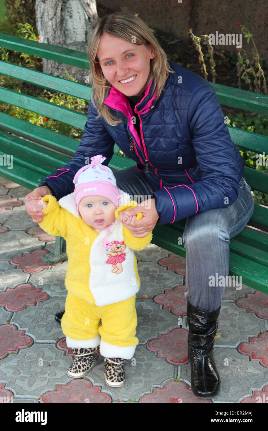 glückliche Mutter führt ihre kleine Tochter und spielt mit Ihrem Stockfoto