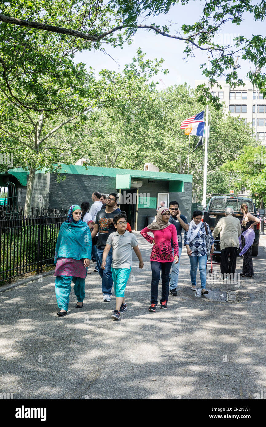 New York City Montag, 25. Mai 2015, USA; Amerikanische Flagge weht auf Halbmast in DeWitt Clinton Park wie entspannte multiethnischen Amerikaner unter alten schattenspendenden Bäumen Credit spazieren: Dorothy Alexander/Alamy Live News Stockfoto