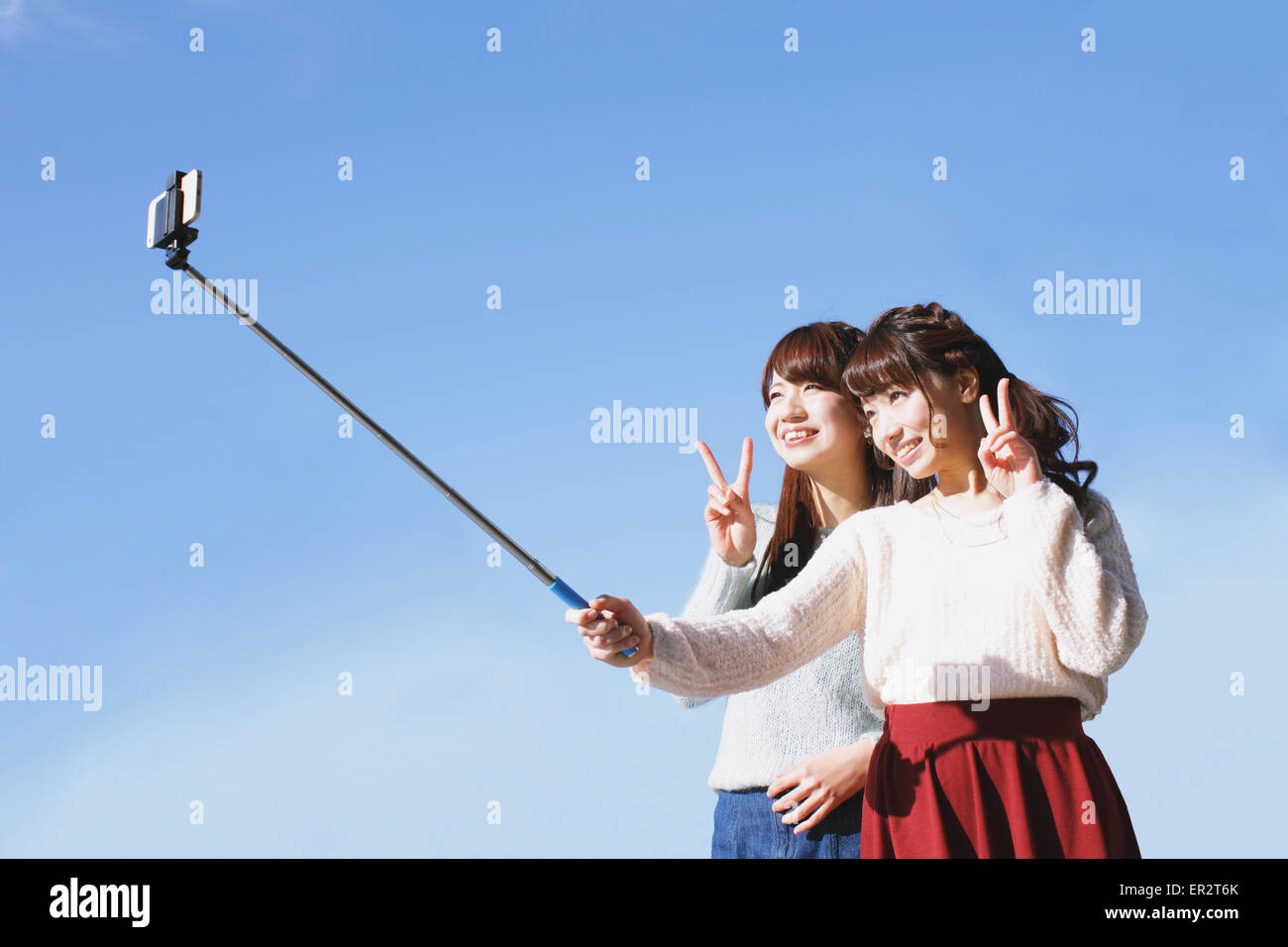Zwei junge japanische Frauen, die eine Selfie mit Selfie stick Stockfoto