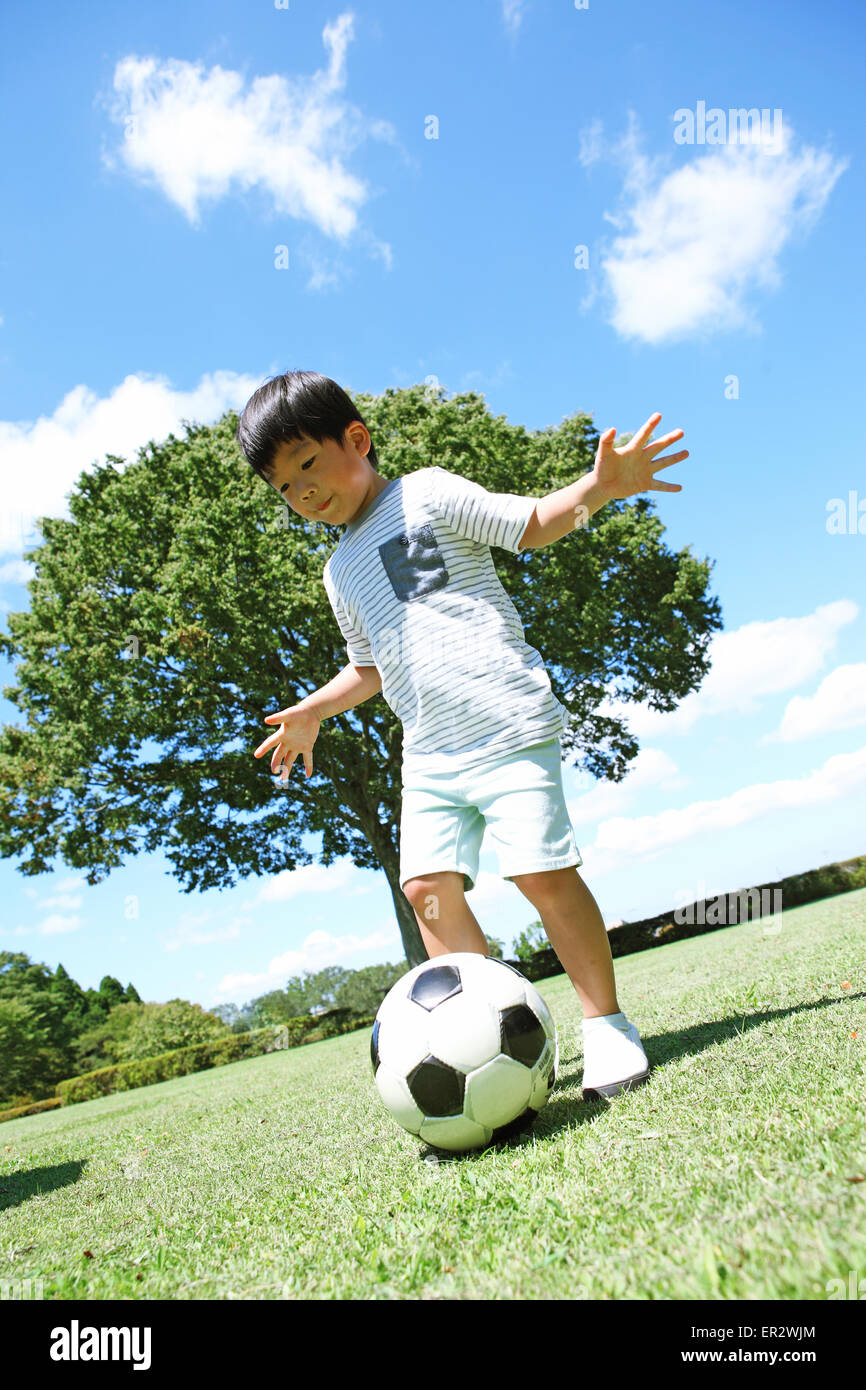 Japanische Jungen spielen Fußball in einem Stadtpark Stockfoto