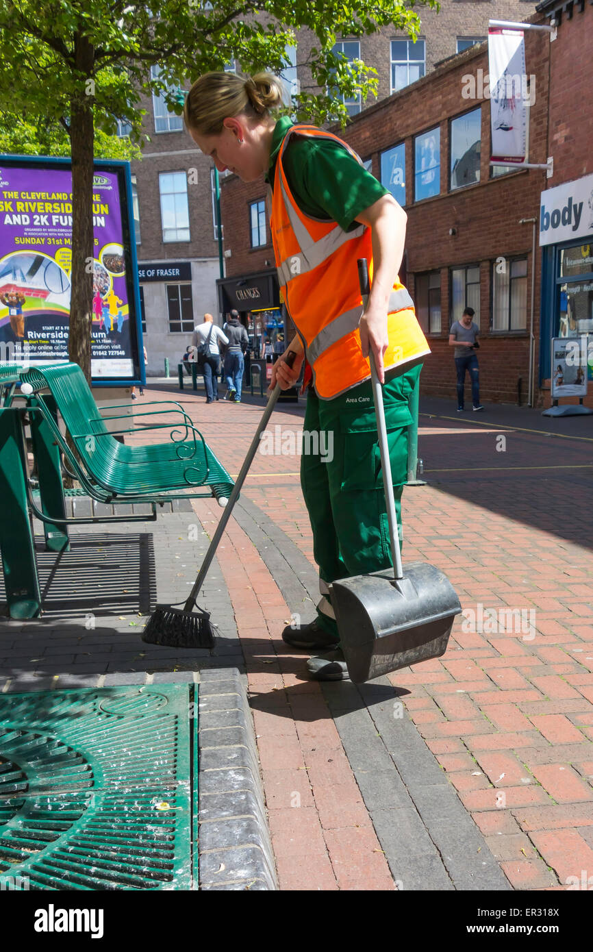 Eine junge Frau Straße sauberer Bestandteil der lokalen Behörde Bereich Betreuerteam eine Fußgängerzone mit einer kleinen Bürste fegen Stockfoto