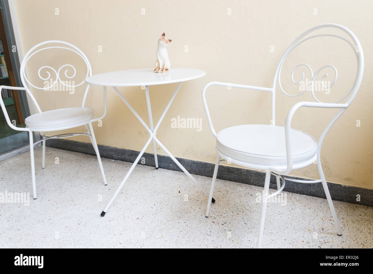 weißer Stuhl und Schreibtisch mit Katze Figur an der Ecke Stockfoto