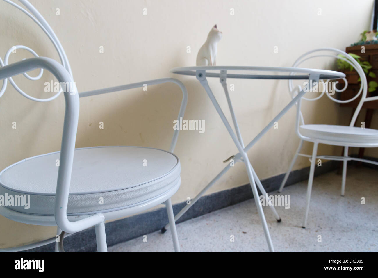 weißer Stuhl und Schreibtisch mit Katze Figur an der Ecke Stockfoto