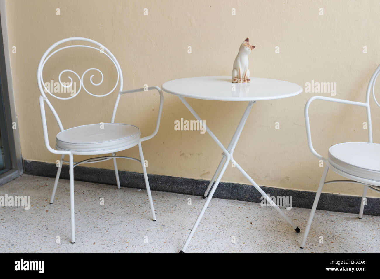 weißer Stuhl und Schreibtisch mit Katze Figur an der Ecke Stockfoto
