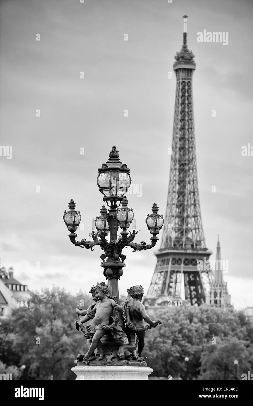 Paris Frankreich Brücke Pont Alexandre III Statuen von Putten auf Straßenlaterne mit Eiffel Tower in schwarz / weiß Stockfoto