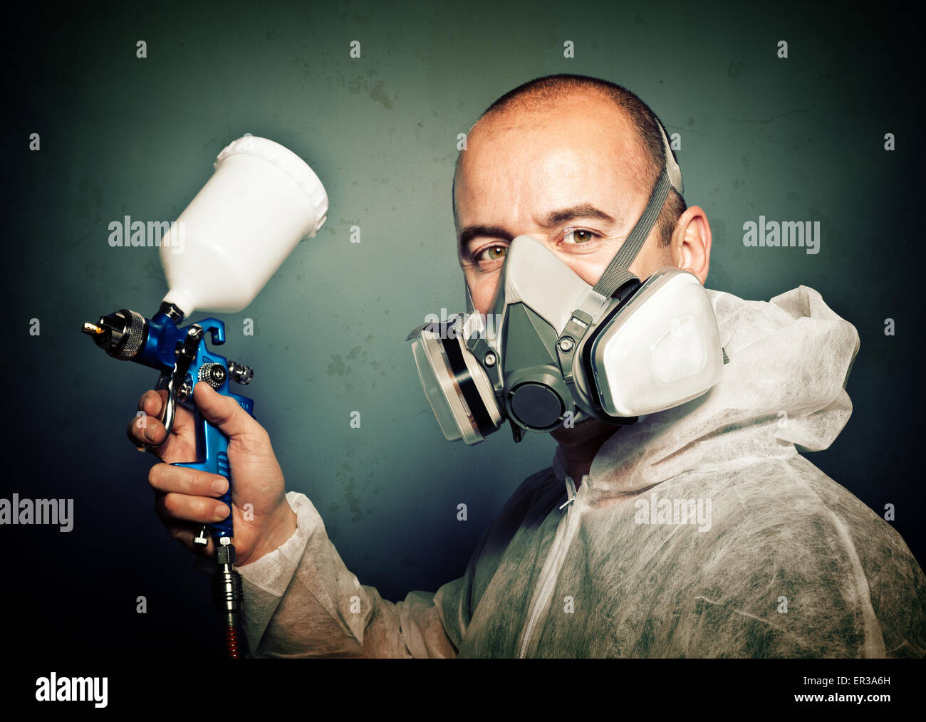 Arbeiter mit Spritzpistole und Schutz Kleidung Stockfoto