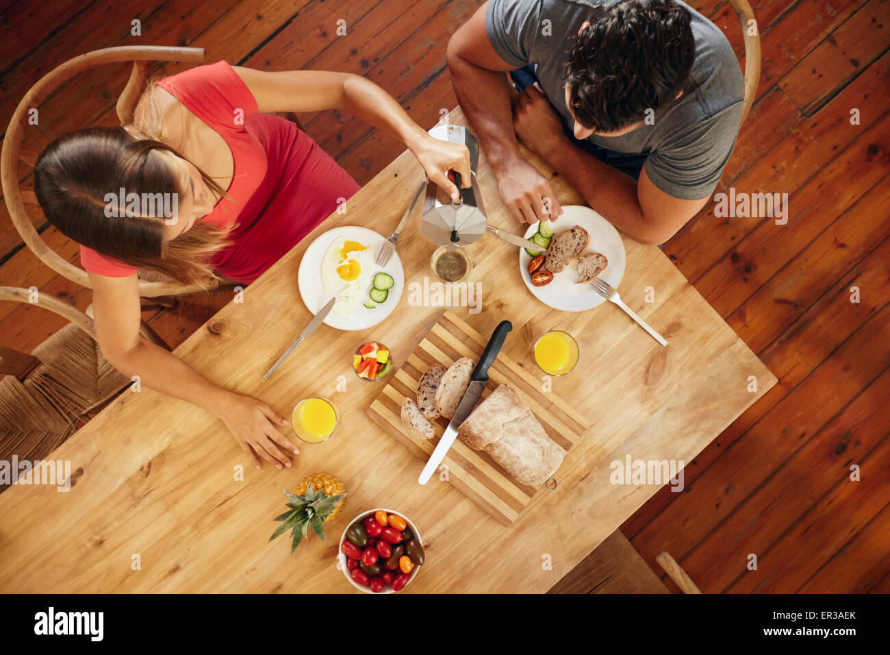Draufsicht eines Paares mit Frühstück am Morgen in Küche mit Frau mit Kaffee auf den Menschen. Stockfoto