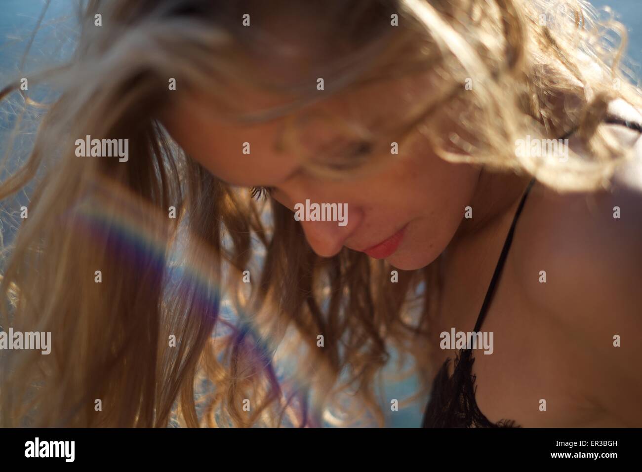 Nahaufnahme einer schönen Frau mit einem Regenbogen aus Licht vor ihrem Gesicht Stockfoto