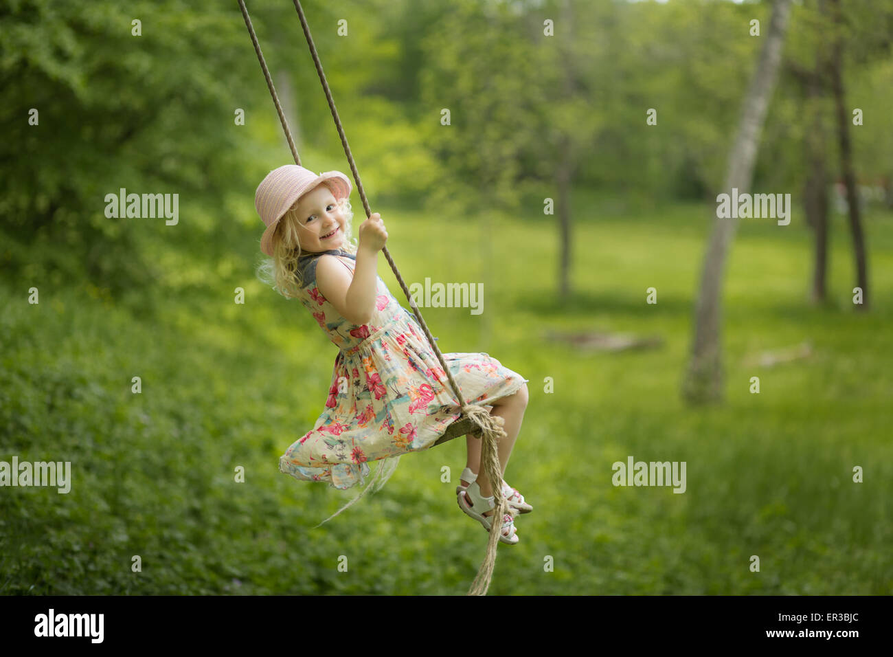 Mädchen auf einer Schaukel im Garten Stockfotografie - Alamy