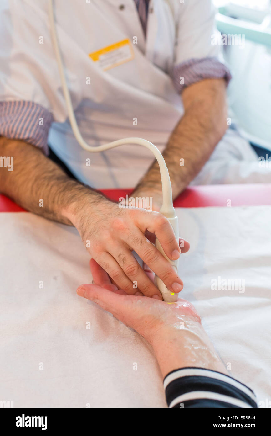 Hand-Ultraschall eines Patienten mit rheumatoider Arthritis, die von einem Rheumatologen durchgeführt. Stockfoto
