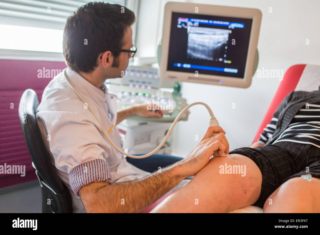 Ultraschall des Knies eines Patienten mit rheumatoider Arthritis unter der Leitung von einem Rheumatologen, Krankenhaus in Bordeaux, Frankreich. Stockfoto