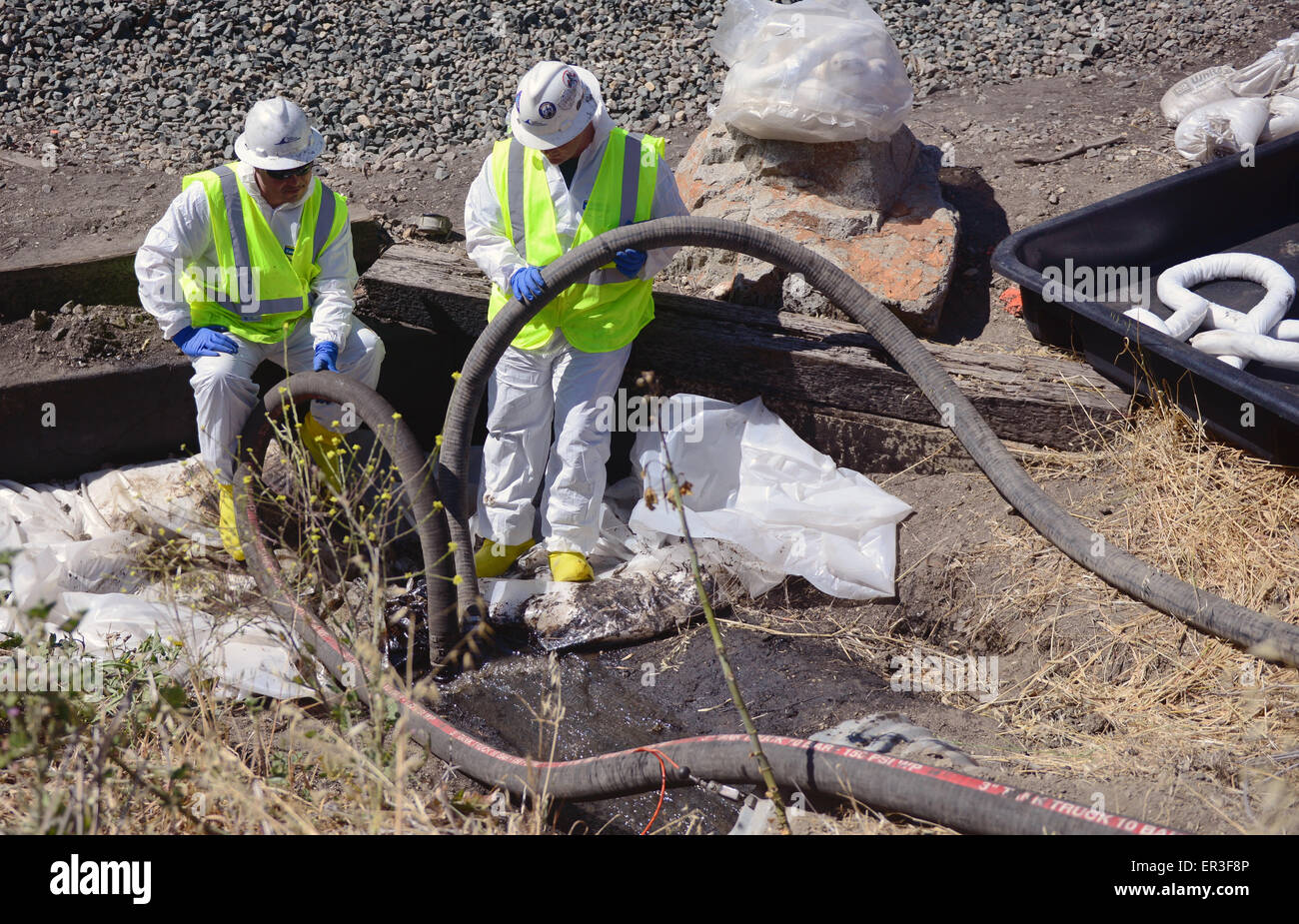 Cleanup Besatzungen überwachen Vakuum-Schläuche, wie sie ölige Wasser während der Bemühungen um eine Entwässerung Düker unter Highway 101 westlich von Rufugio State Beach Cleanup 24. Mai 2015 in der Nähe von Santa Barbara, Kalifornien abgeschöpft. Mehr als 105.000 Gallonen Rohöl sickerte aus einer Pipeline in einem der schönsten Abschnitte der Küste des Staates. Stockfoto
