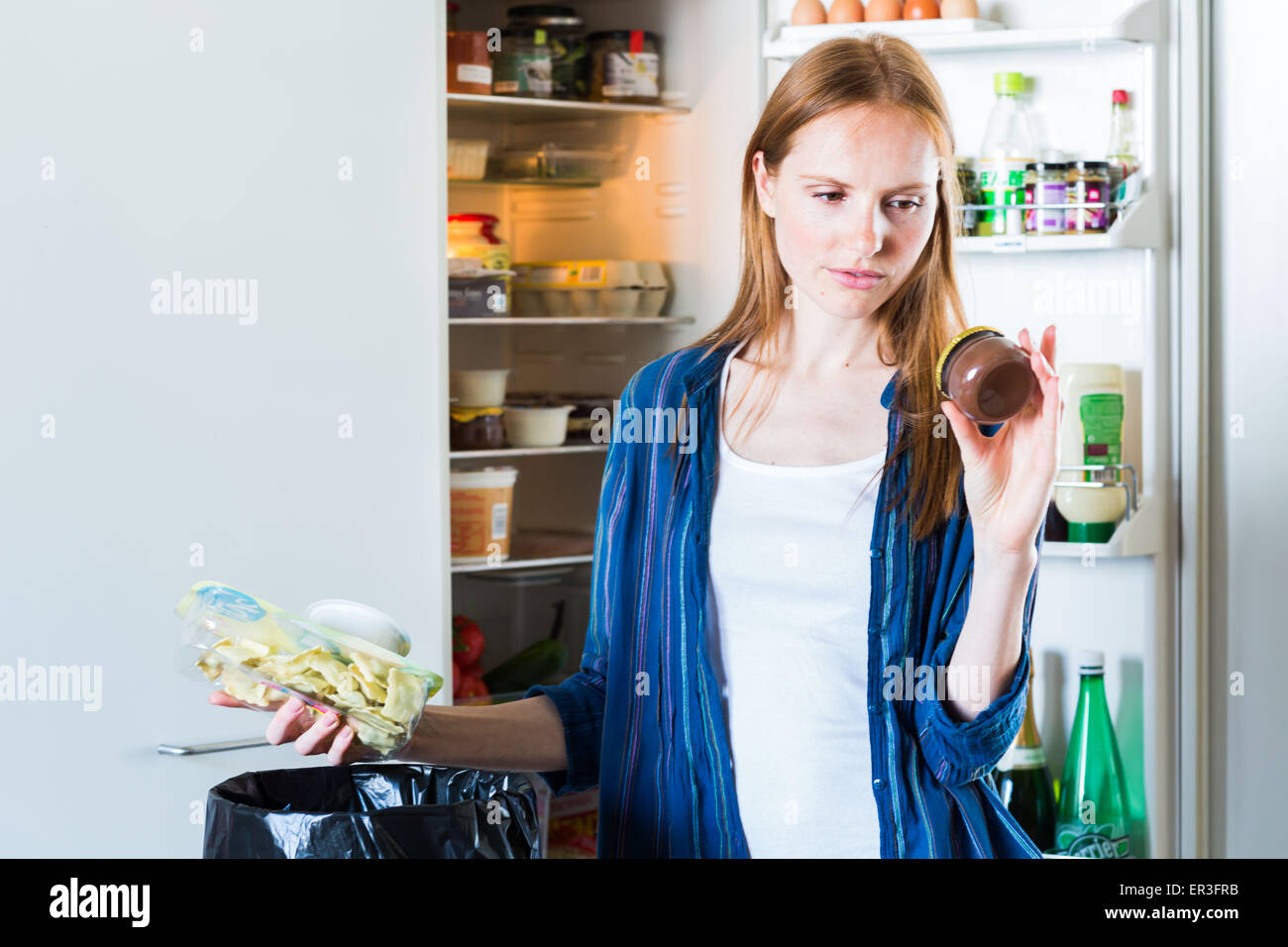 Frau, Essen in den Müll zu werfen. Stockfoto