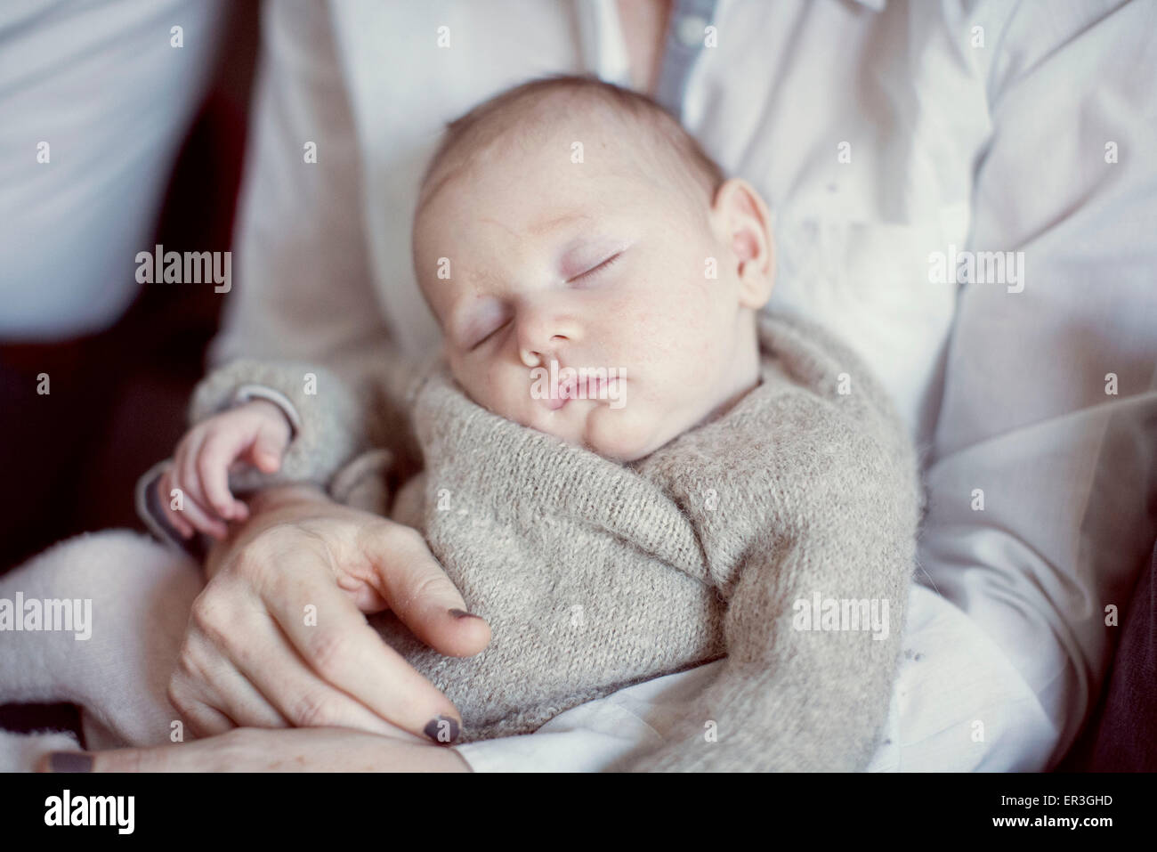 Baby schläft auf Mutters Schoß, beschnitten Stockfoto