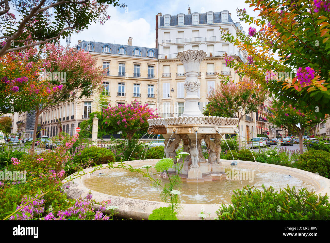 Alter Brunnen und bunten Blumen in der Mitte des Place Francois 1er, Paris, Frankreich Stockfoto