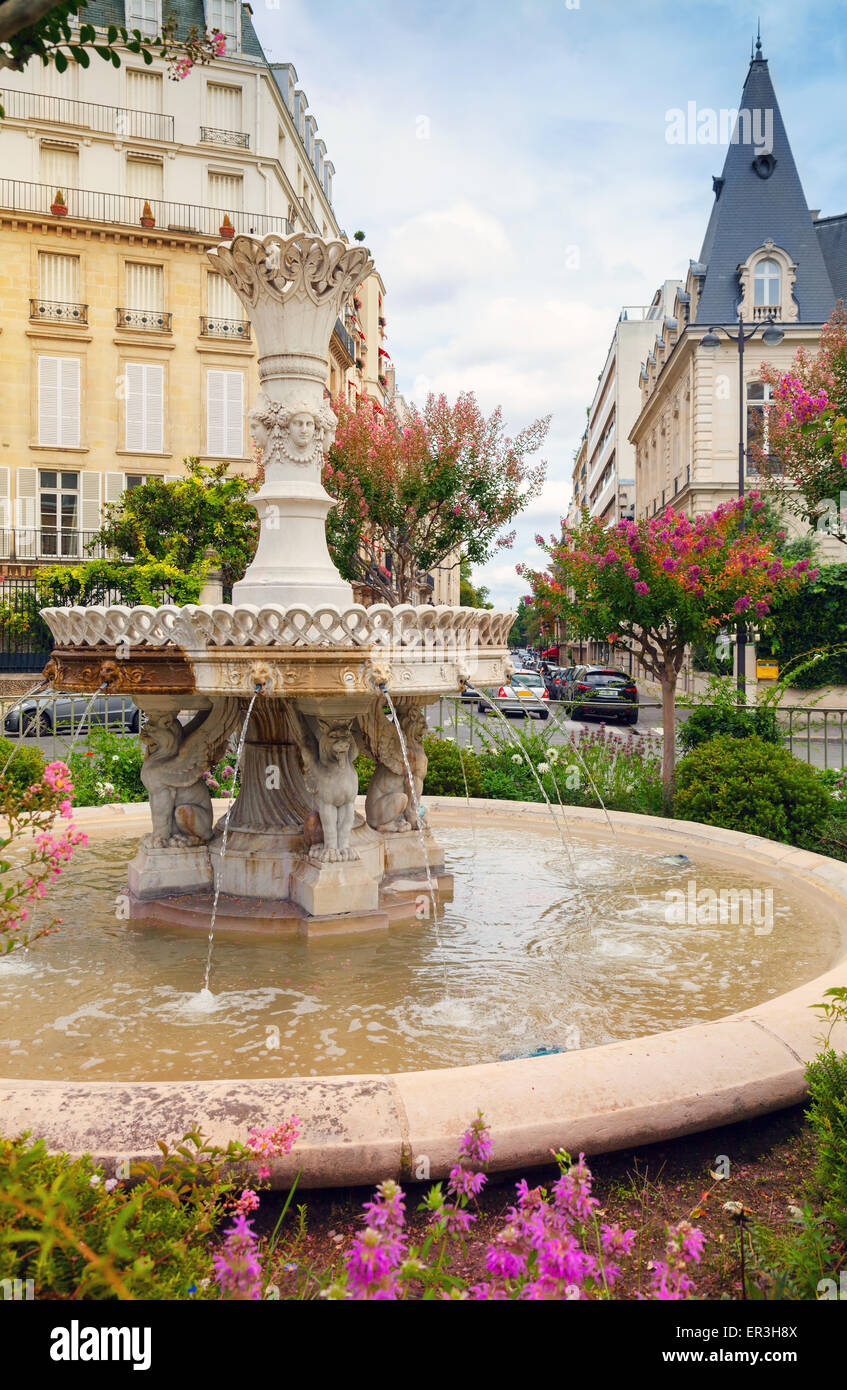 Alter Brunnen und Blumen in der Mitte des Place Francois 1er, Paris, Frankreich Stockfoto
