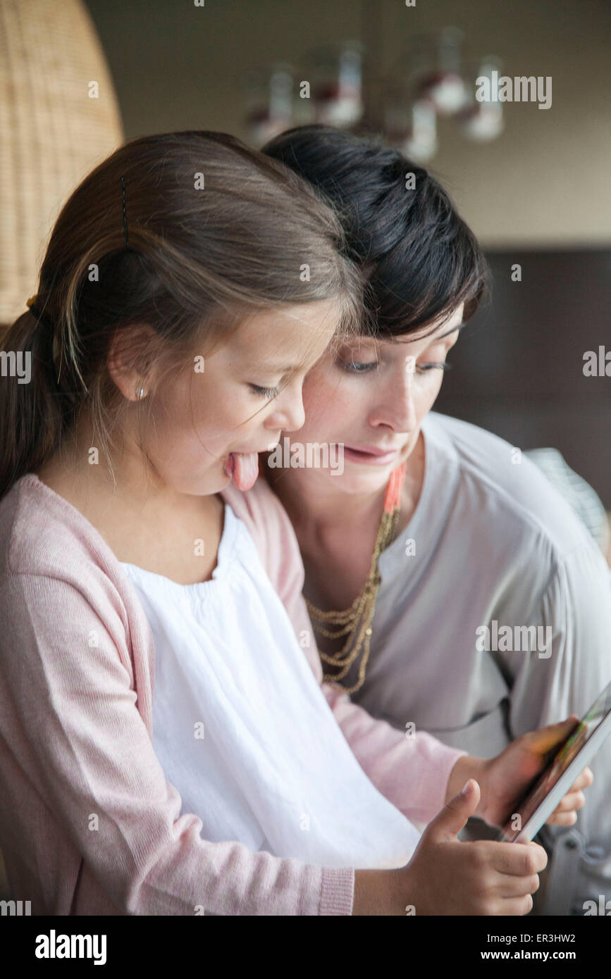 Mutter und junge Tochter mit digital-Tablette und lustige Grimassen Stockfoto