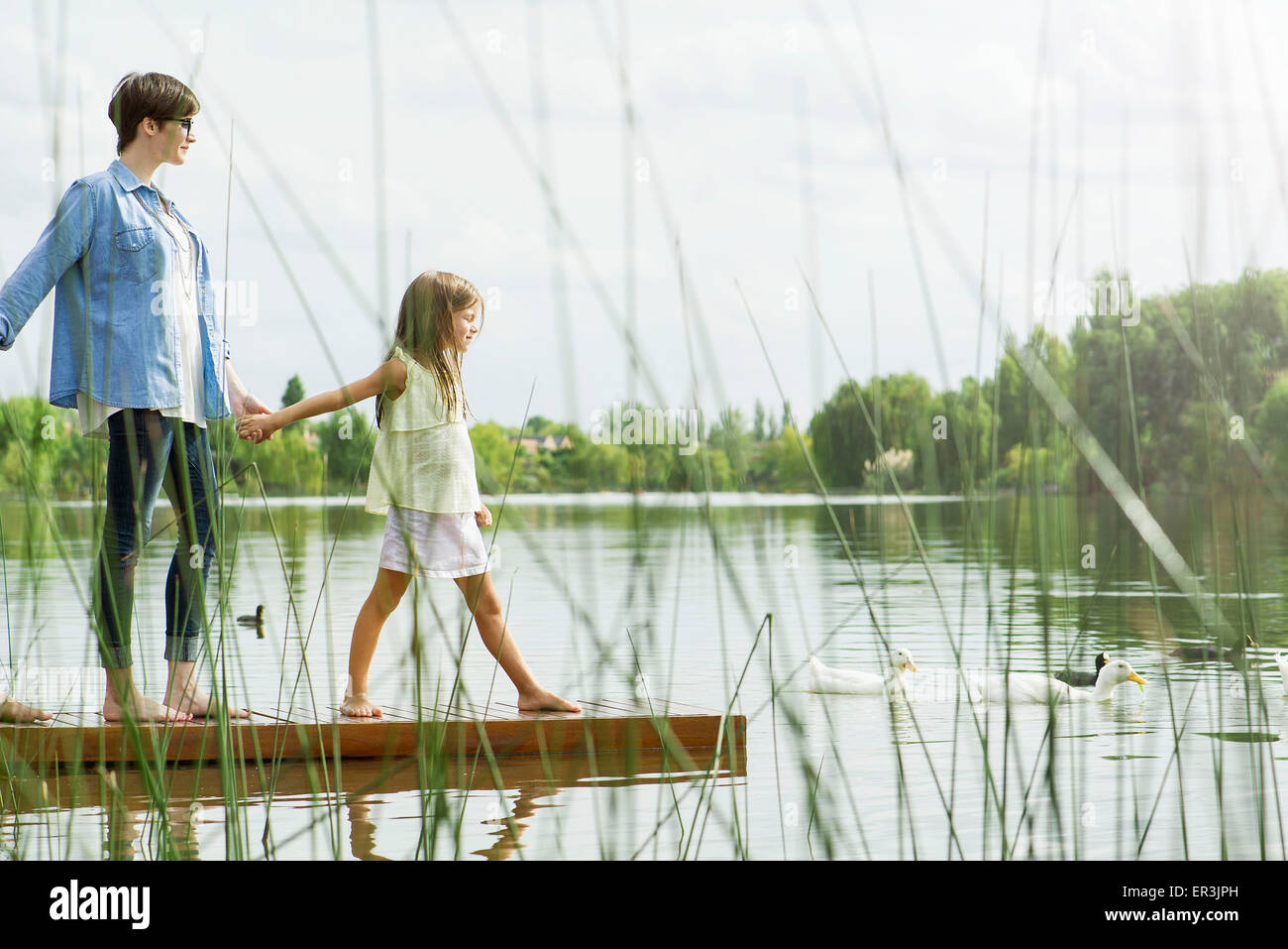 Mutter und Tochter halten die Hände auf dock Stockfoto